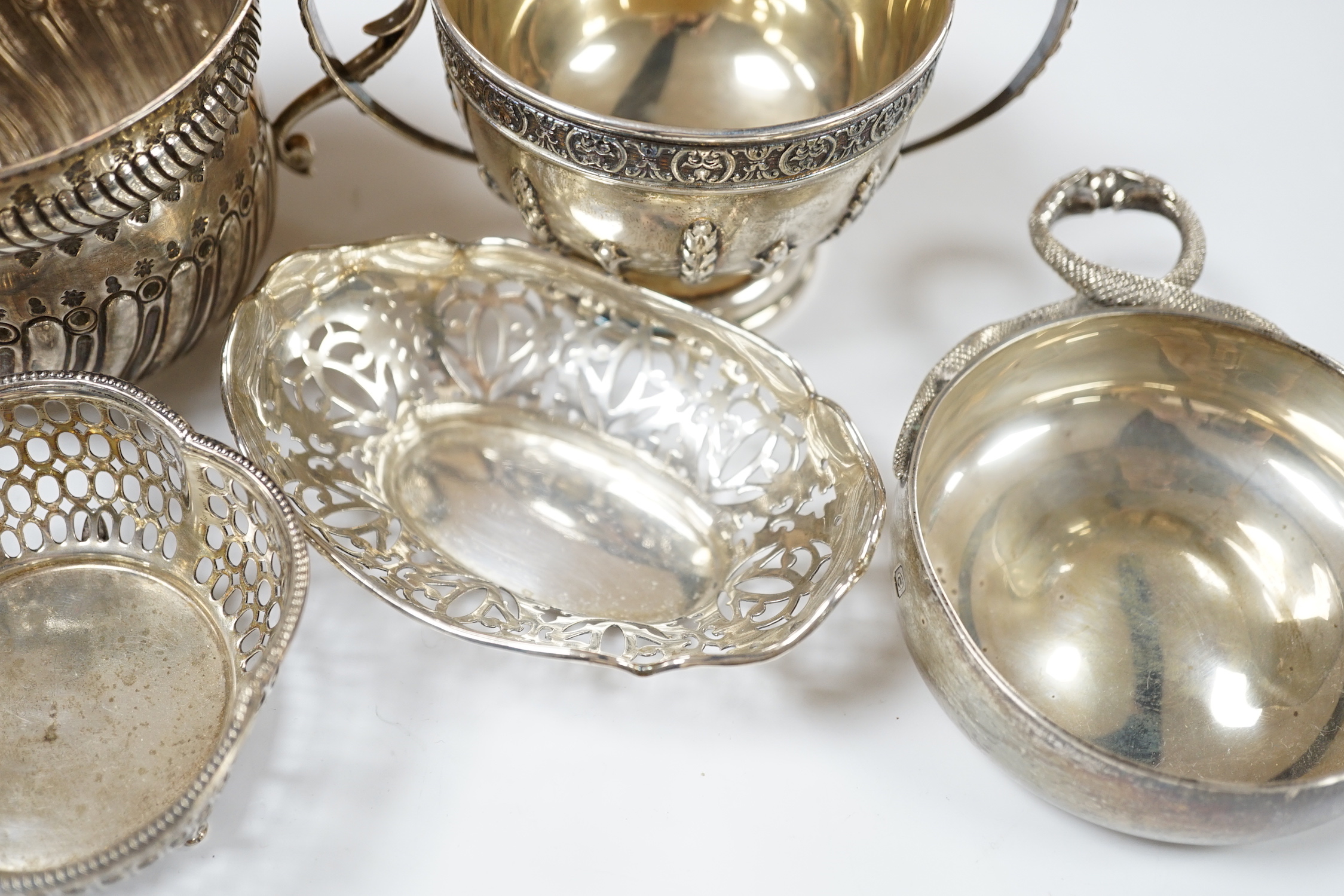 An Edwardian repousse silver porringer, Daniel & John Welby, London, 1905, diameter 92mm, a pair of pierced silver bonbon dishes, one other similar bonbon dish, a silver two handled bowl and a modern silver taste vin